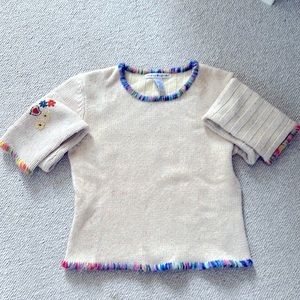 Tan sweater with flecks of color throughout.